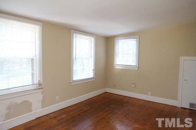 810 Chamberlain Street Raleigh, NC 27607 - Photo 13 of 16 a view of an empty room with wooden floor and a window