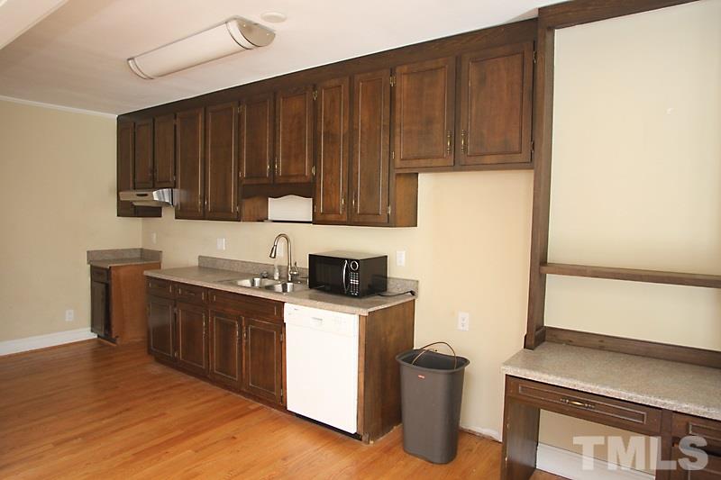 810 Chamberlain Street Raleigh, NC 27607 - Photo 7 of 16 a kitchen with a sink cabinets and wooden floor