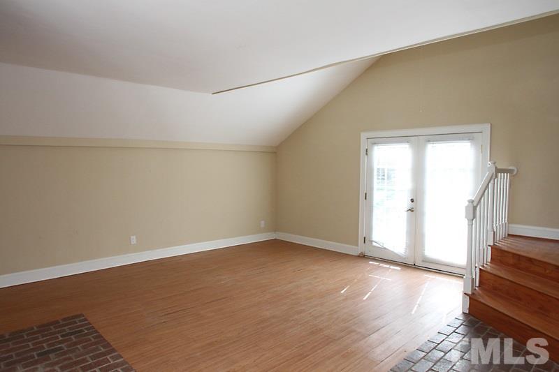 810 Chamberlain Street Raleigh, NC 27607 - Photo 9 of 16 an empty room with wooden floor and windows
