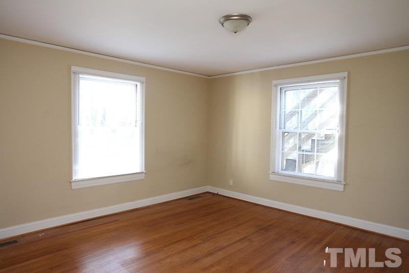 810 Chamberlain Street Raleigh, NC 27607 - Photo 10 of 16 a view of an empty room with wooden floor and a window
