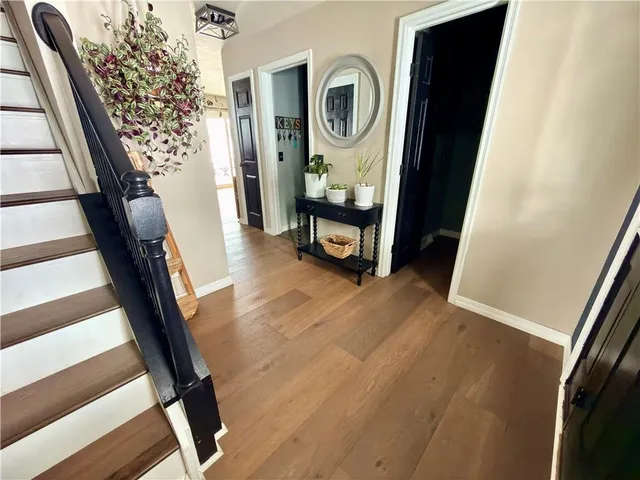 a kitchen with stainless steel appliances granite countertop a sink a stove and a wooden floors