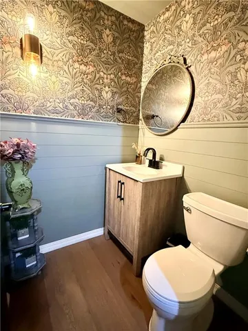 a kitchen with stainless steel appliances a refrigerator a sink a stove a microwave and wooden floor