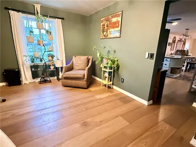 a kitchen with stainless steel appliances kitchen island granite countertop a refrigerator a stove a sink dishwasher and white cabinets with wooden floor