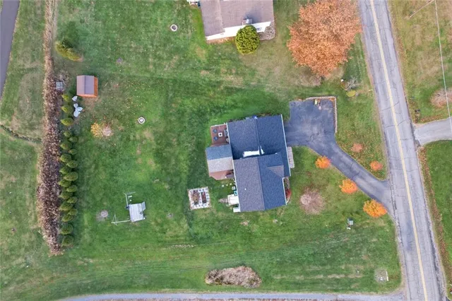 a aerial view of a house with table and chairs in a big yard
