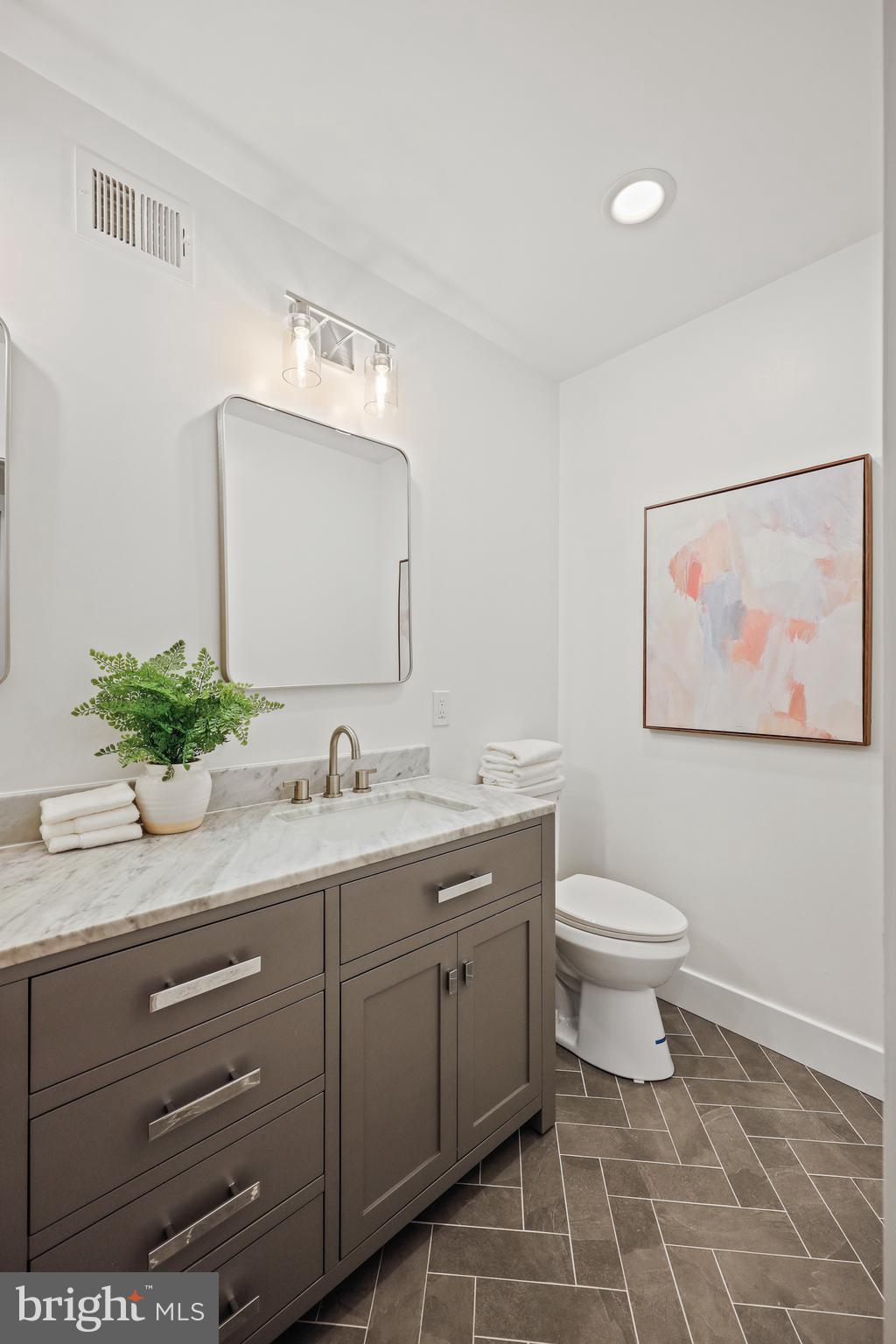 1465 Towson Street Baltimore, MD 21230 - Photo 20 of 39 a bathroom with a toilet a sink and mirror