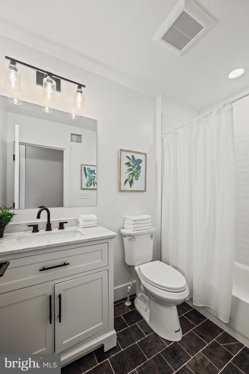 1465 Towson Street Baltimore, MD 21230 - Photo 24 of 39 a bathroom with a toilet sink vanity and mirror
