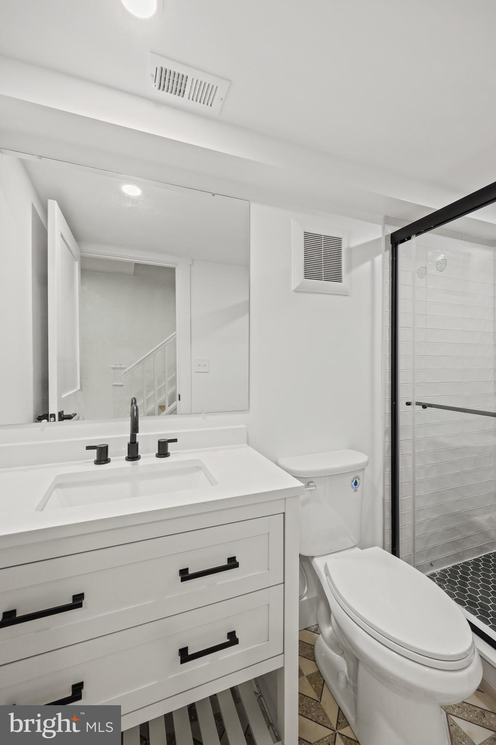 1465 Towson Street Baltimore, MD 21230 - Photo 32 of 39 a bathroom with a sink a toilet a mirror and vanity