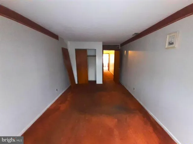 a view of an empty room with closet and a fireplace
