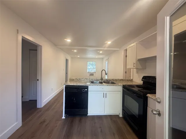 a kitchen with granite countertop a sink and cabinets