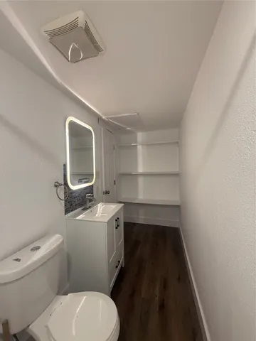 a bathroom with a toilet sink and mirror