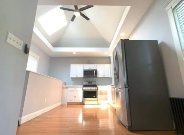 a kitchen with granite countertop a refrigerator and a stove top oven