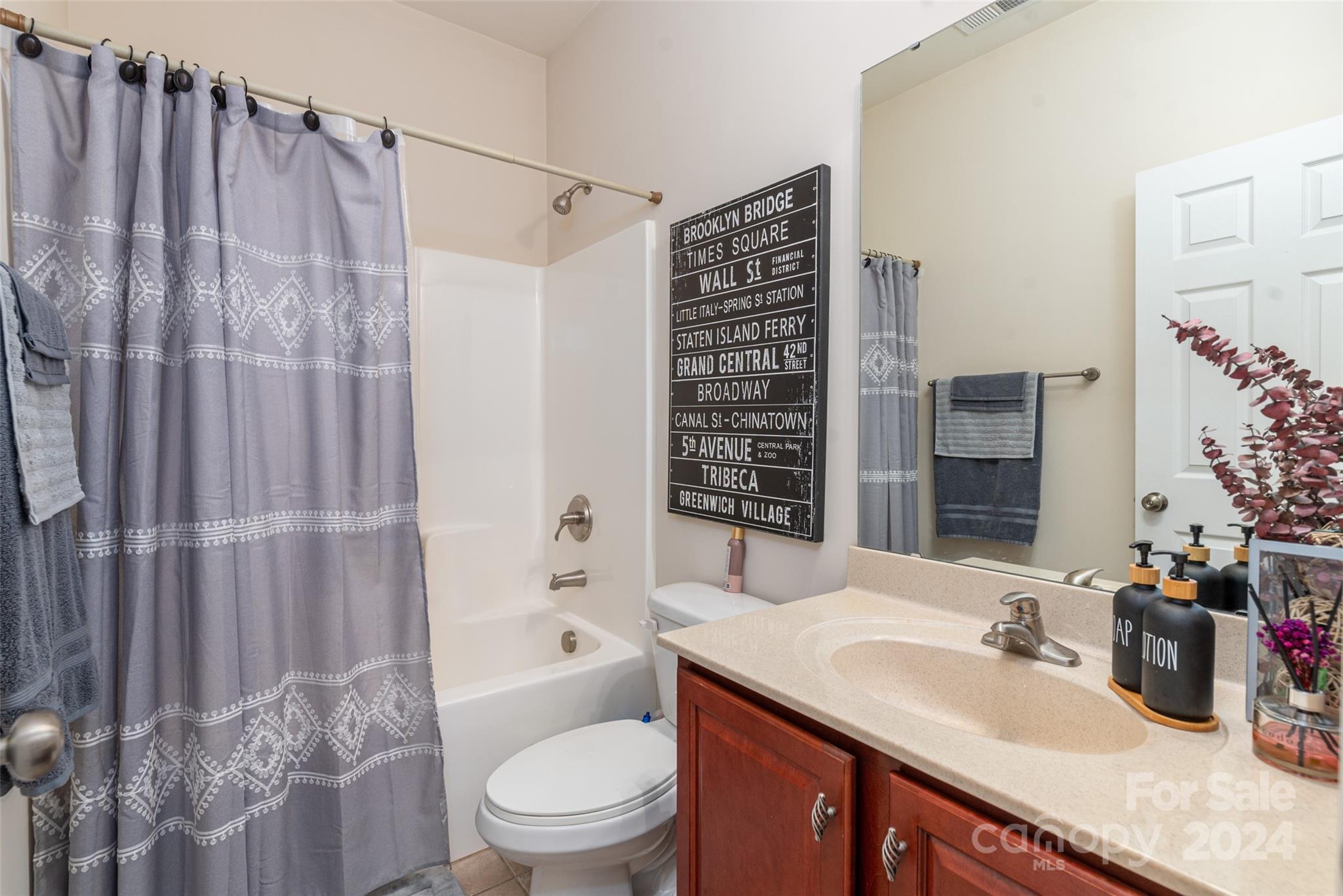 6013 Fox Cub Indian Land, SC 29707 - Photo 23 of 30 a bathroom with a granite countertop sink a toilet a mirror and shower curtain