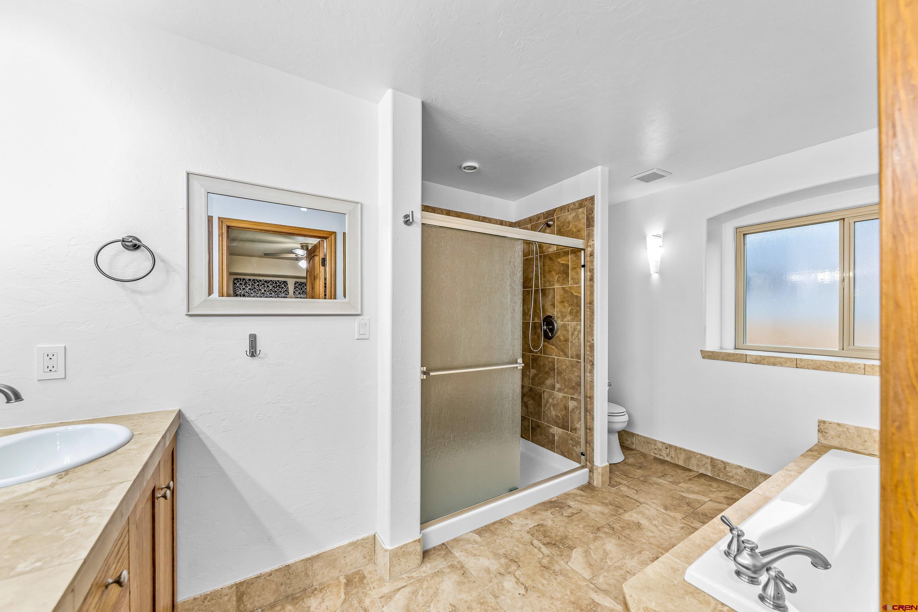 1455 Criterion Street Delta, CO 81416 - Photo 11 of 27 a bathroom with a granite countertop sink mirror and shower