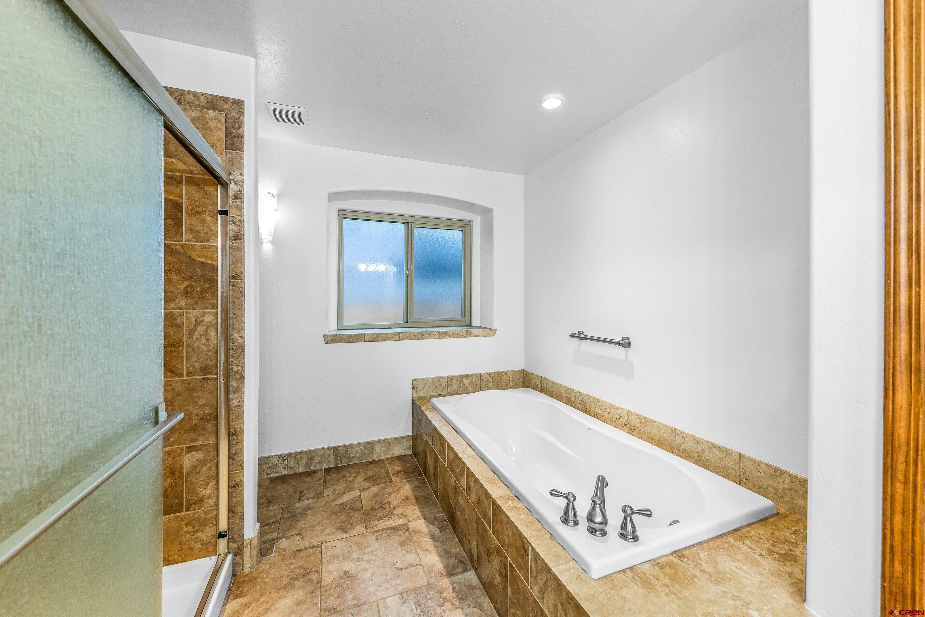1455 Criterion Street Delta, CO 81416 - Photo 12 of 27 a bathroom with a tub and shower