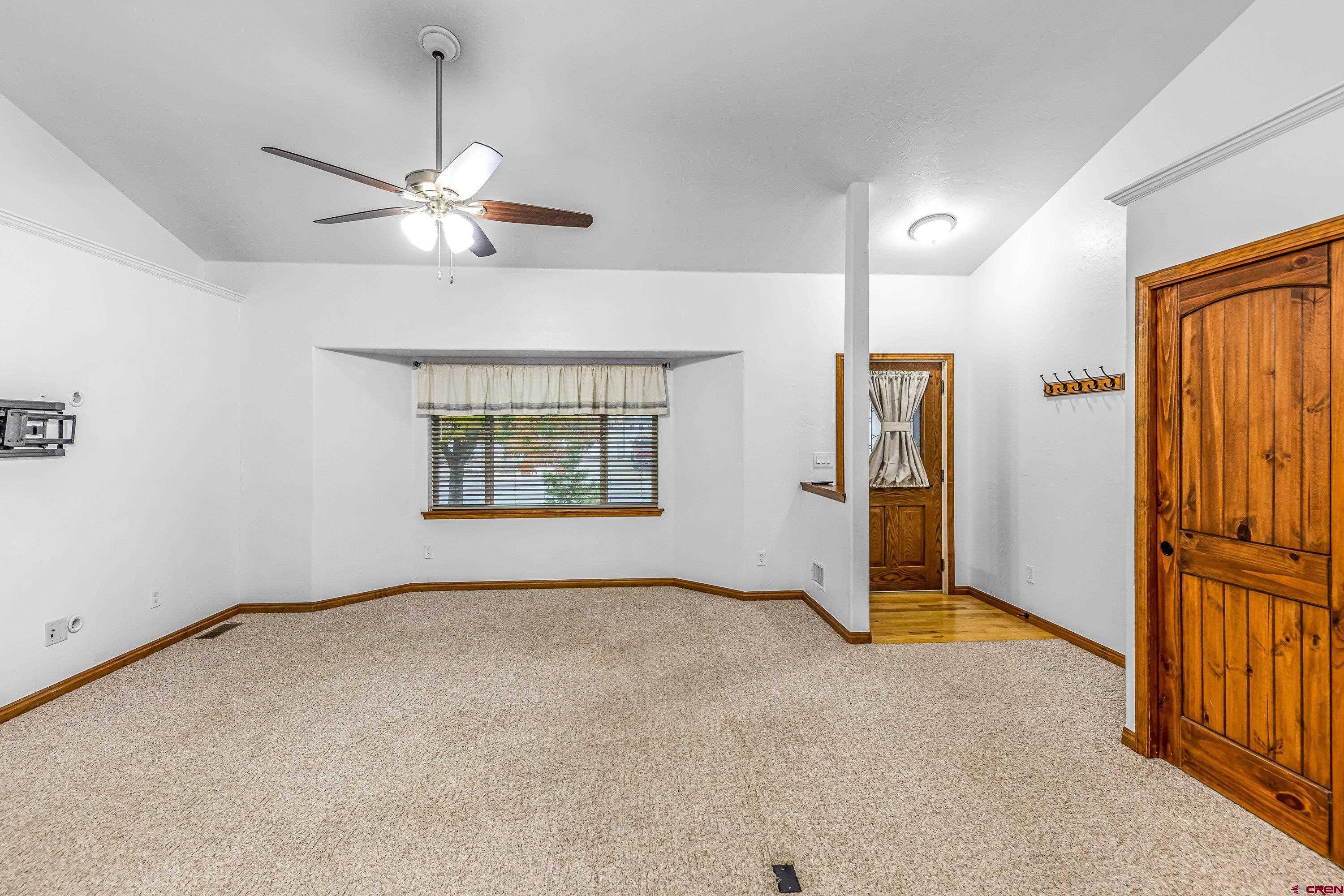 1455 Criterion Street Delta, CO 81416 - Photo 5 of 27 an empty room with chandelier fan and windows