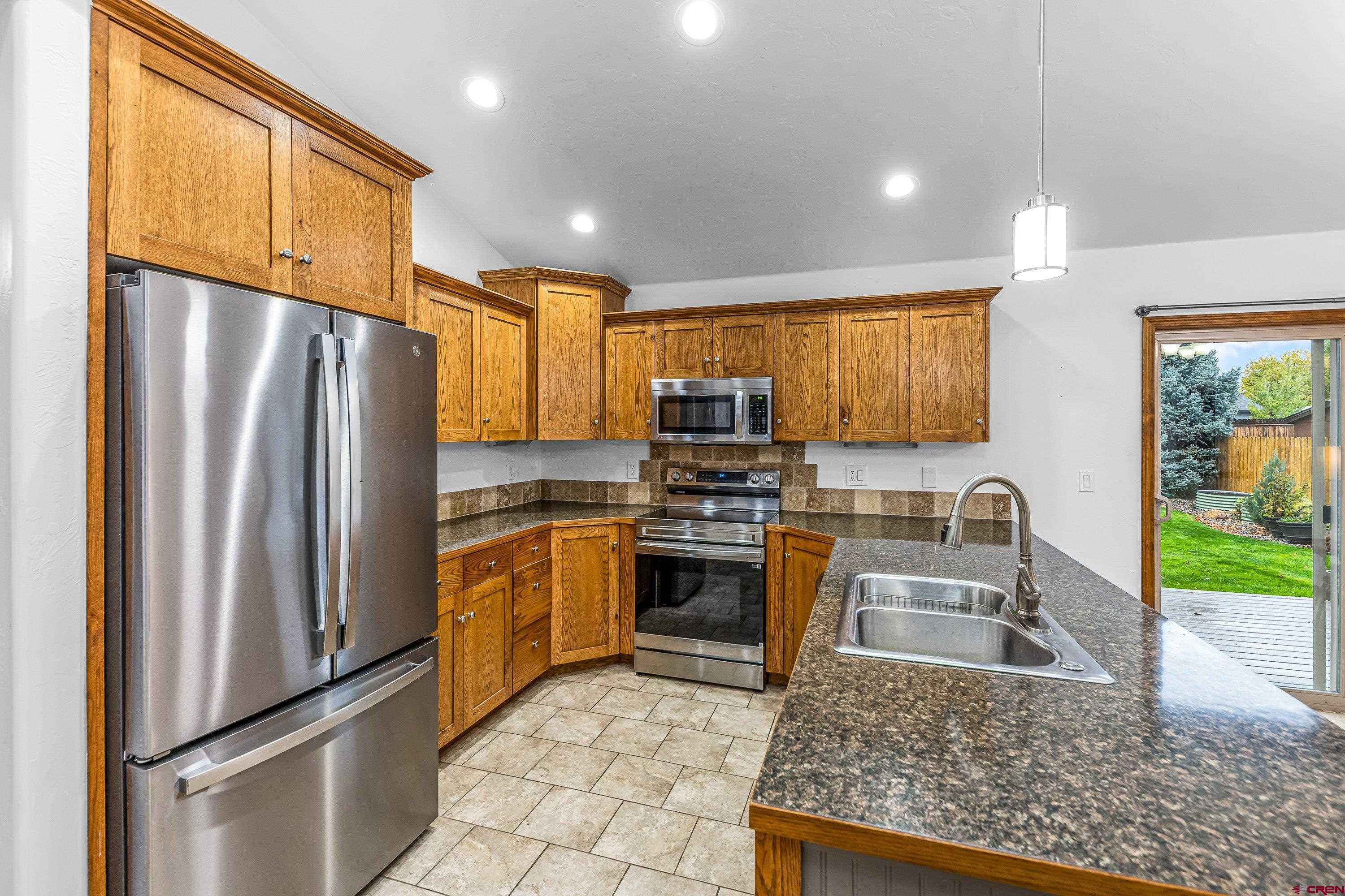1455 Criterion Street Delta, CO 81416 - Photo 8 of 27 a kitchen with stainless steel appliances granite countertop a refrigerator a stove top oven a sink and dishwasher