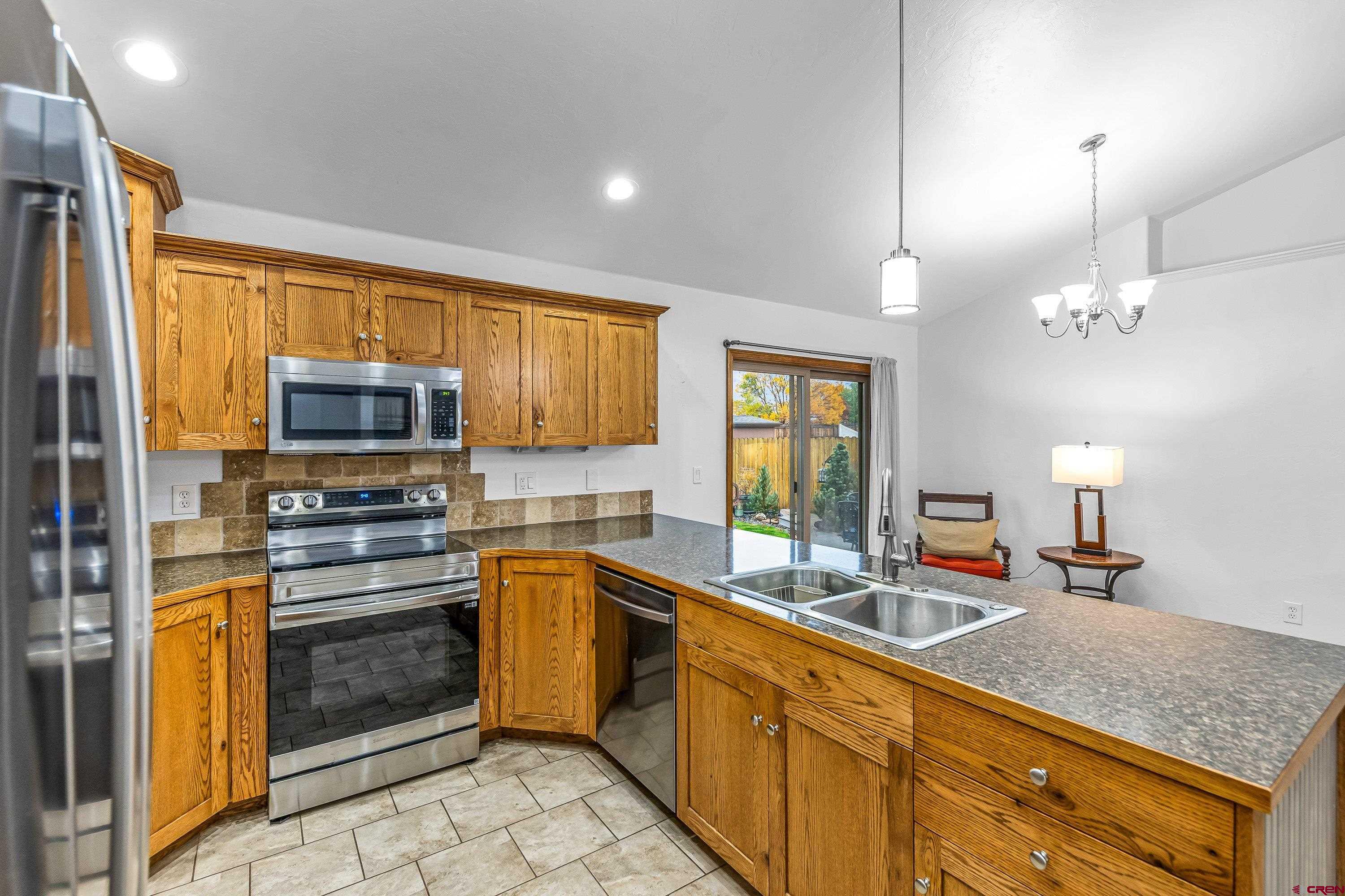 1455 Criterion Street Delta, CO 81416 - Photo 9 of 27 a kitchen with stainless steel appliances a stove sink microwave and cabinets