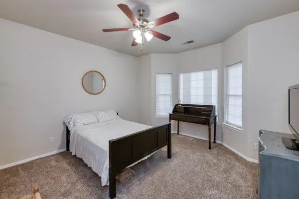 a spacious bedroom with a bed and a chandelier
