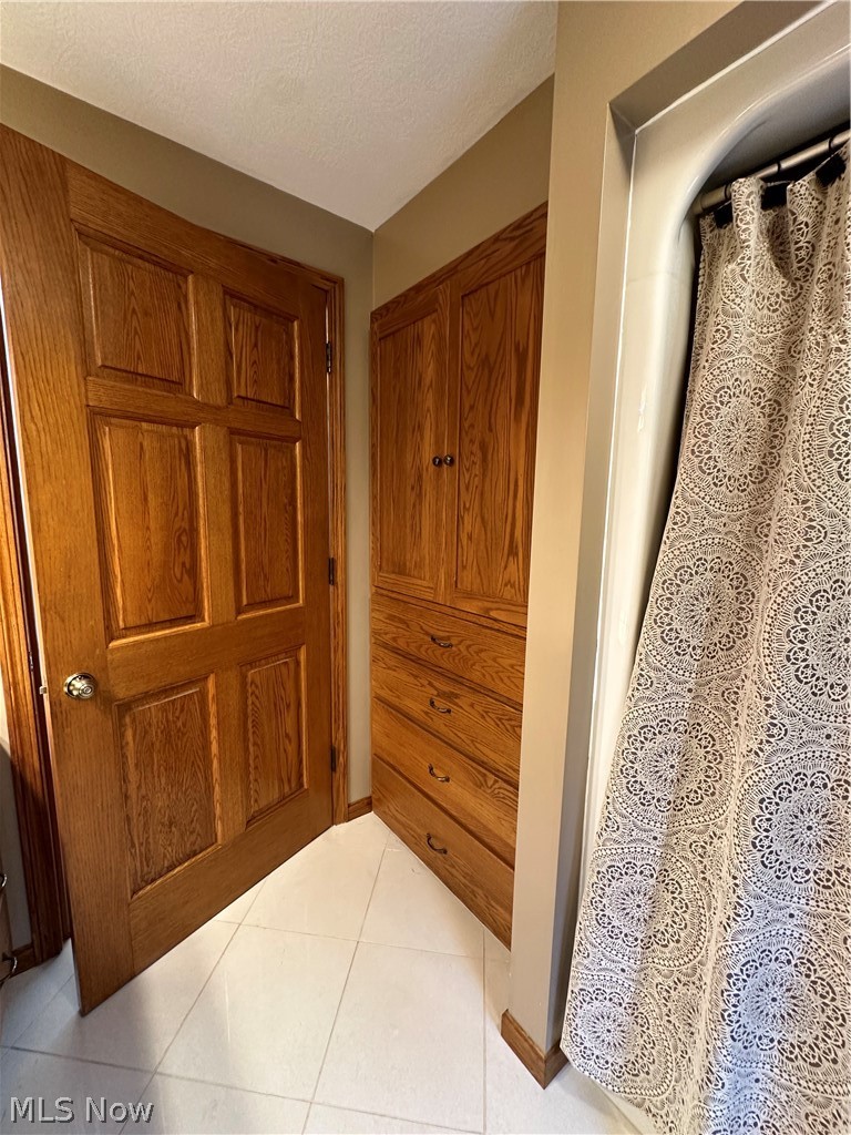 5233 Secrest Road Wooster, OH 44691 - Photo 33 of 33 Hallway with light tile patterned floors and a textured ceiling