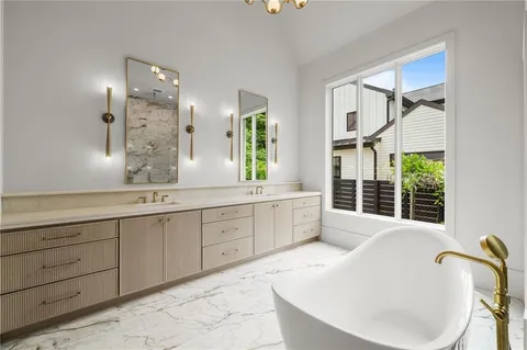 a spacious bathroom with a tub sink and mirror