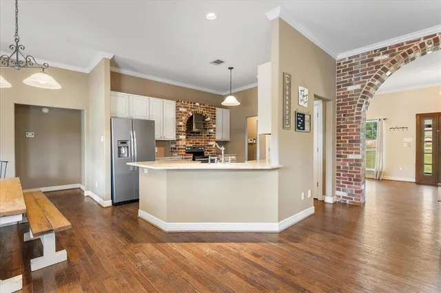 a view of kitchen with stainless steel appliances refrigerator stove microwave and cabinets