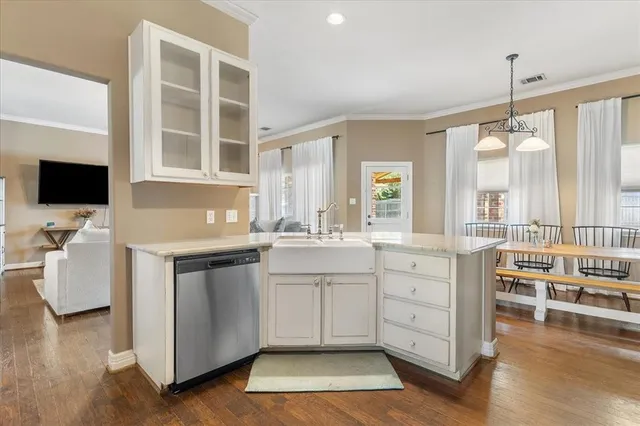 a kitchen with stainless steel appliances granite countertop a refrigerator and a wooden floor