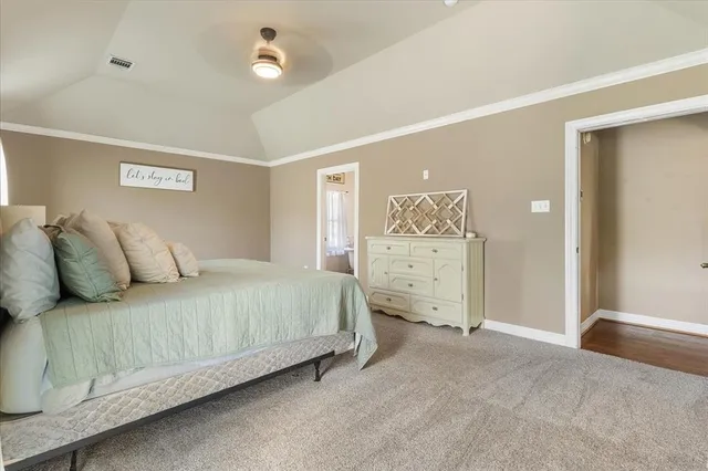 a spacious bedroom with a bed and a chandelier