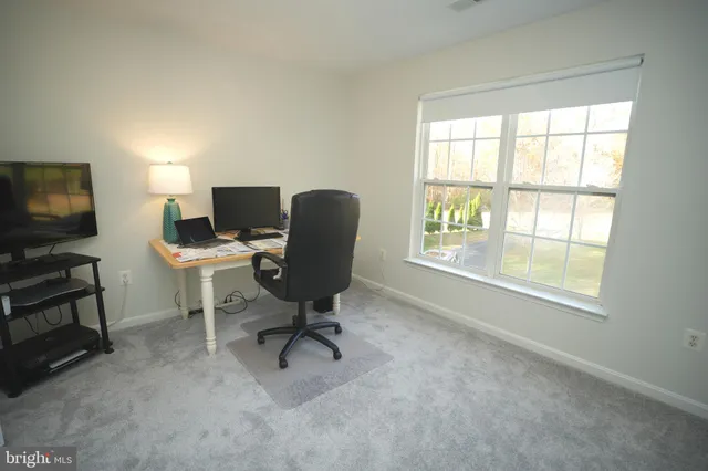 a view of a workspace with furniture and a window