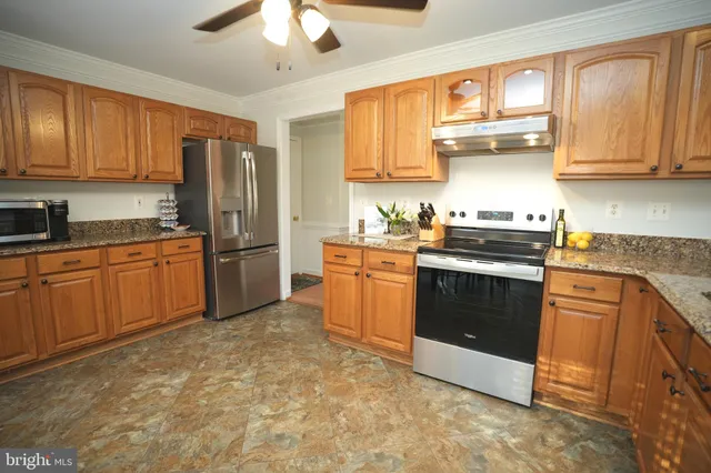 a kitchen with stainless steel appliances granite countertop a stove a sink dishwasher and a refrigerator