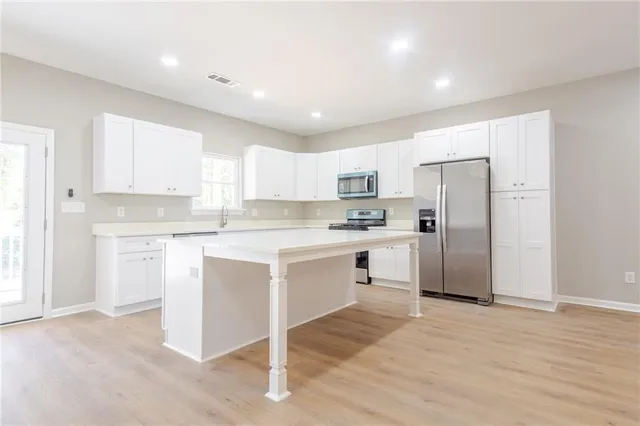 a kitchen with white cabinets and white appliances