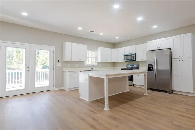 a kitchen with white cabinets and stainless steel appliances