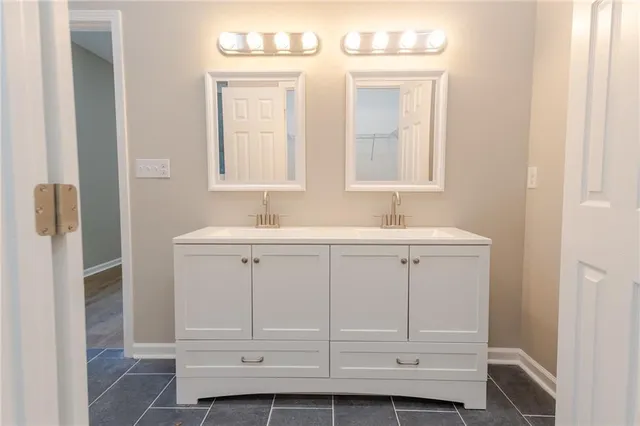 a bathroom with a sink vanity and mirror