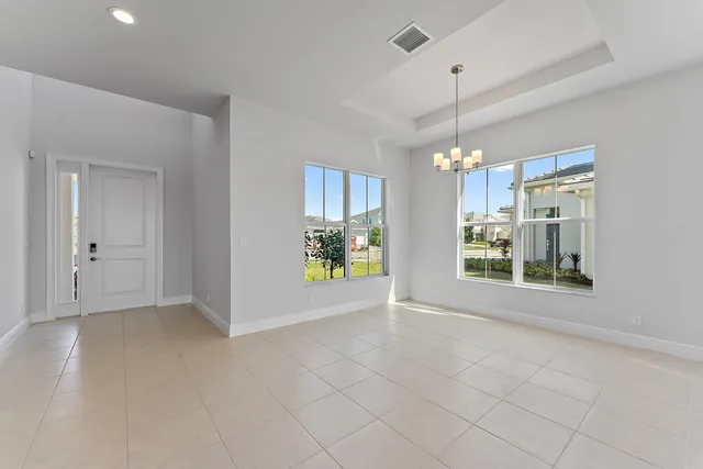 a large white kitchen with stainless steel appliances lots of white cabinets