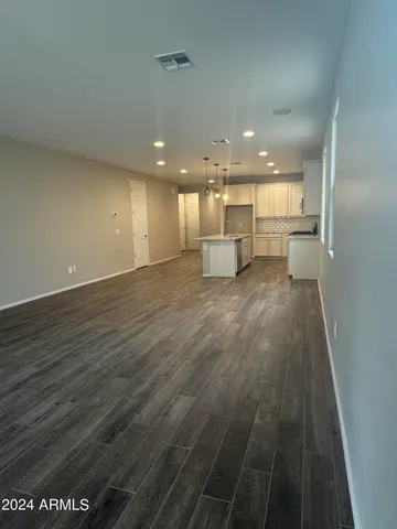 a view of a kitchen with kitchen island a sink wooden floor and a counter top space