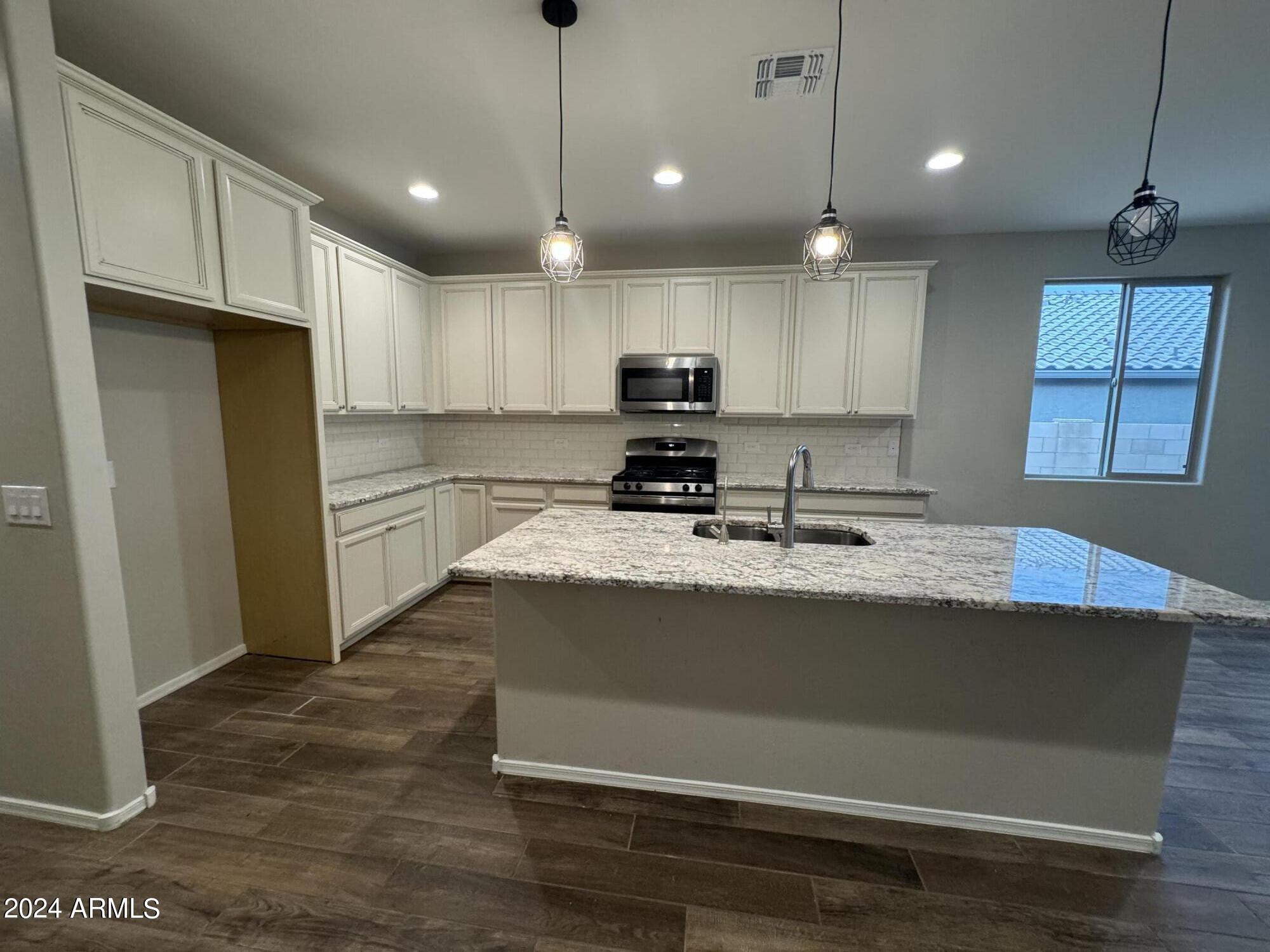 10207 South Moonlit Riverwalk Trail Vail, AZ 85641 - Photo 15 of 21 a kitchen with kitchen island a counter top space a sink stainless steel appliances and cabinets