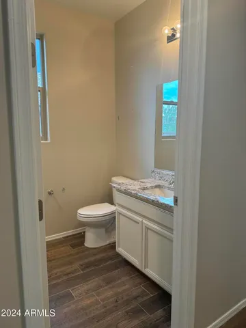 a bathroom with a granite countertop toilet and a sink