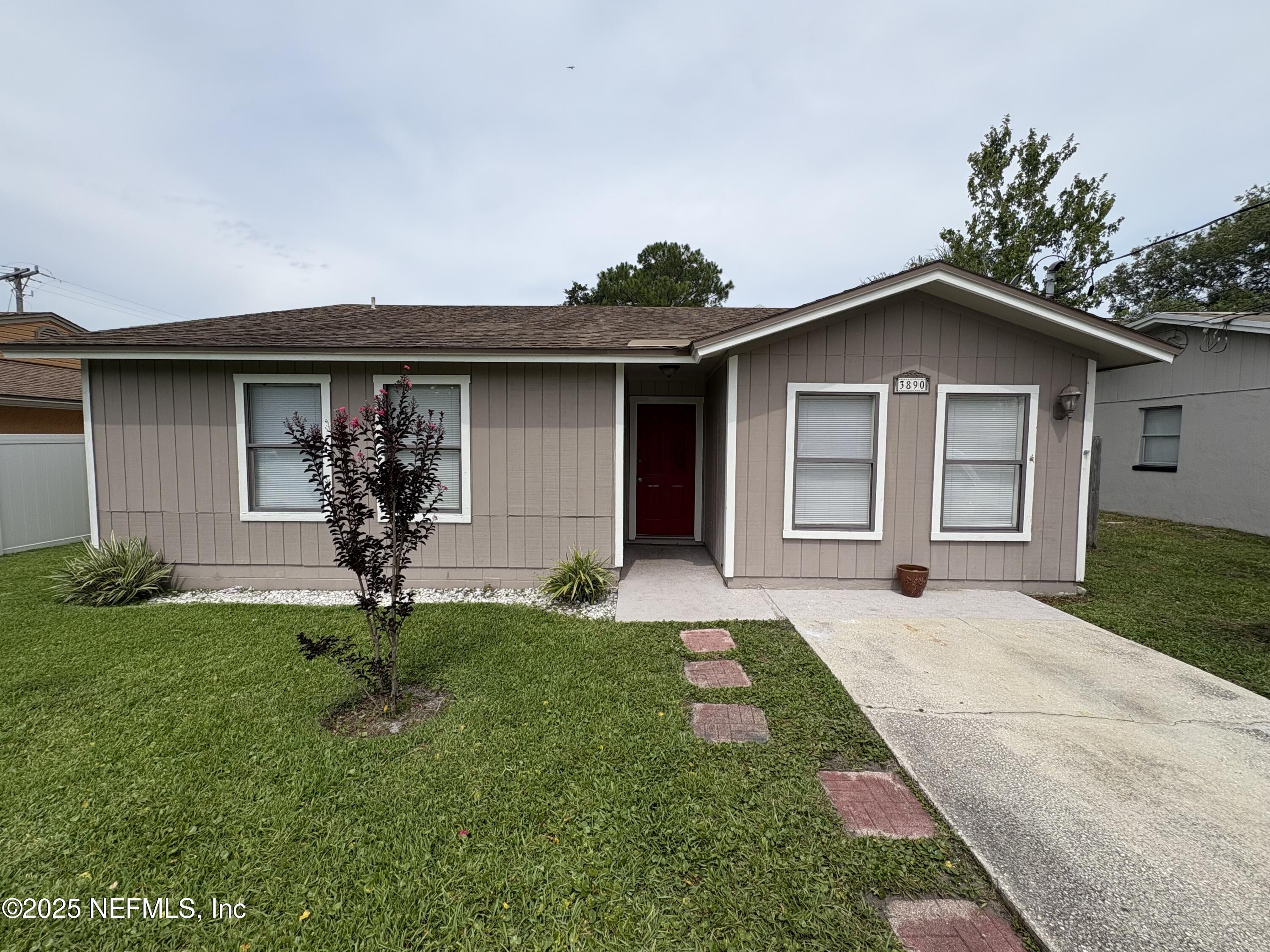 3890 Eunice Road Jacksonville, FL 32250 - Photo 2 of 3 a front view of a house with a yard and garage