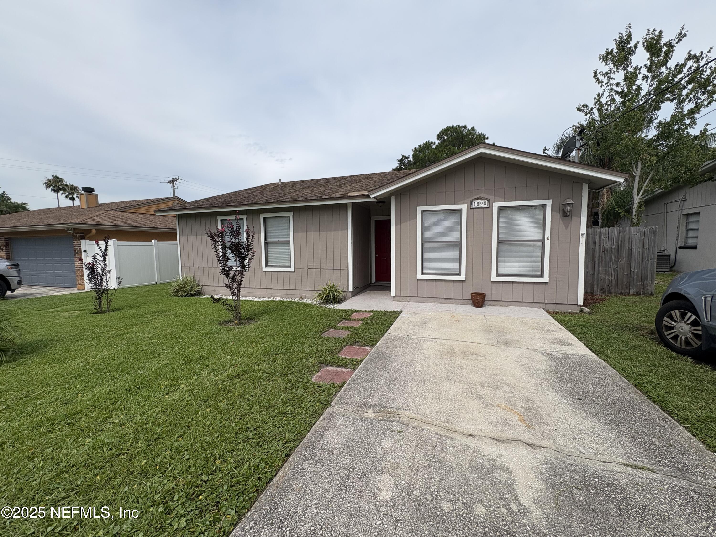 3890 Eunice Road Jacksonville, FL 32250 - Photo 3 of 3 a front view of a house with a yard and garage