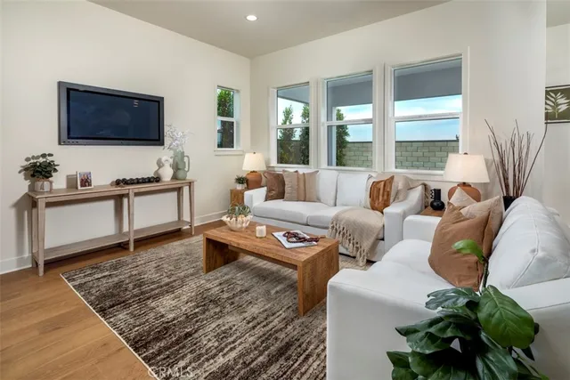 a living room with furniture wooden floor and a flat screen tv