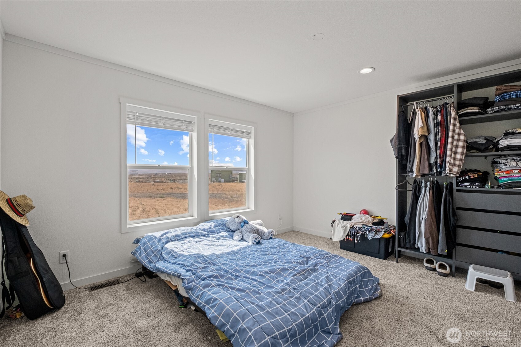910 Canyon Trail Ephrata, WA 98823 - Photo 14 of 30 a bedroom with a bed a large window and walk in closet with wooden floor