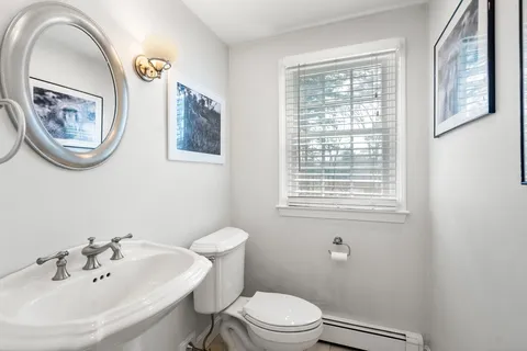 a bathroom with a toilet a sink and mirror