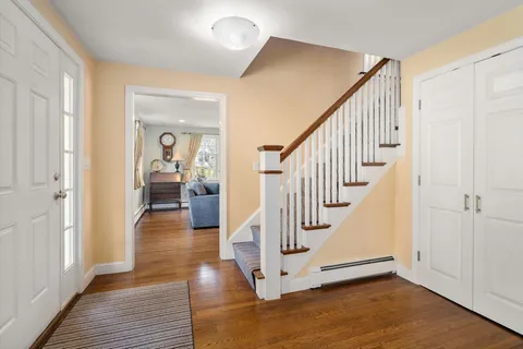 a view of a hallway with wooden floor and staircase