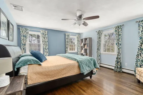 a bedroom with a large bed and wooden floor