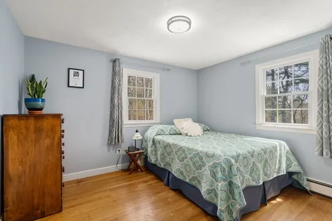 a bedroom with a bed table and a window