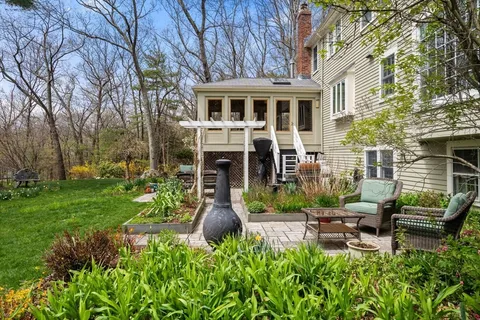 a view of a house with backyard sitting area and garden