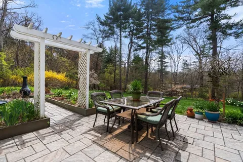 a view of a patio with a table and chairs and potted plants