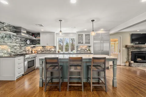 a kitchen with kitchen island granite countertop a sink counter and chairs