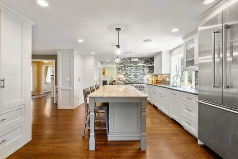 a kitchen with kitchen island white cabinets and stainless steel appliances