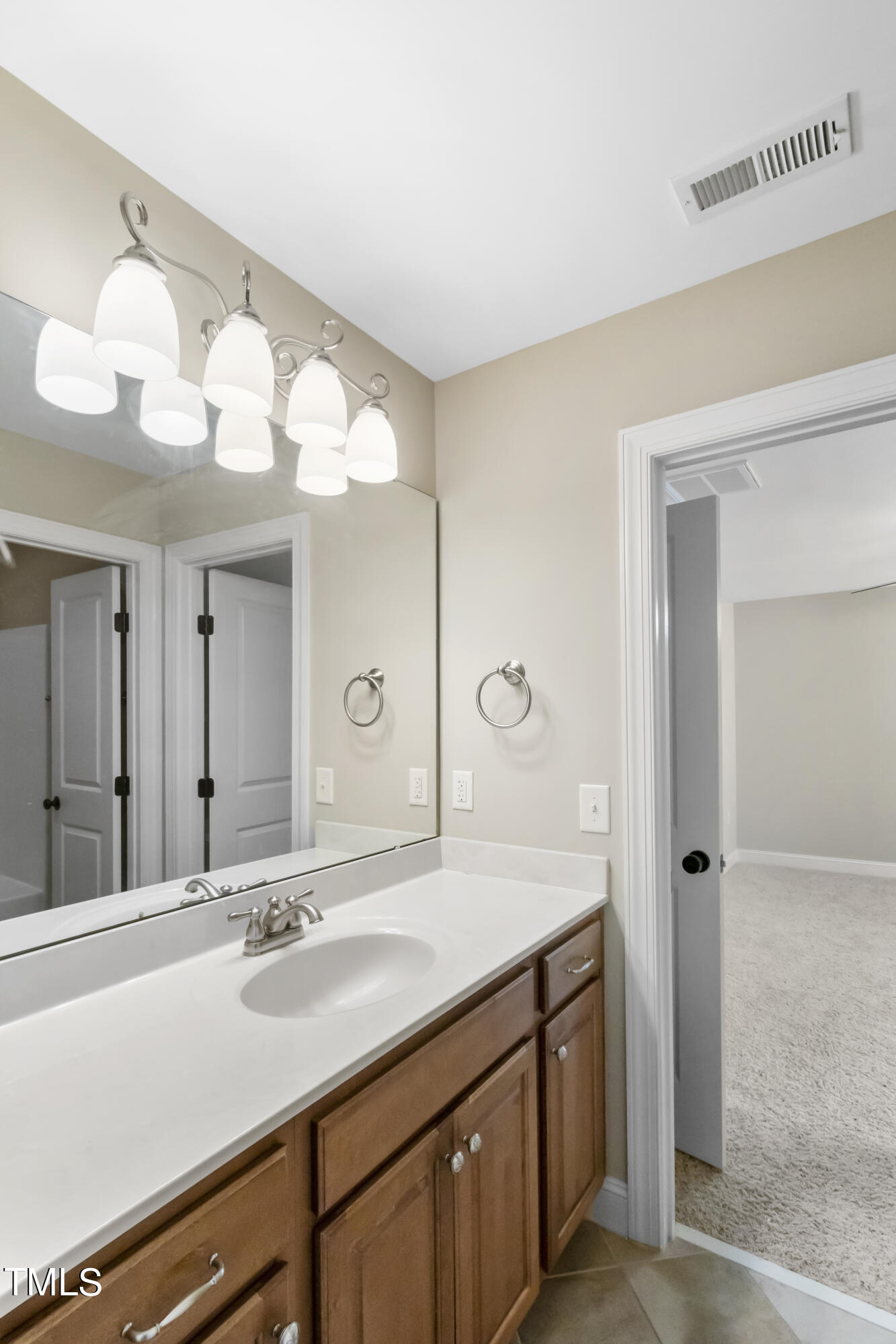6507 Glendower Road Raleigh, NC 27613 - Photo 30 of 42 a bathroom with a double vanity sink and a mirror