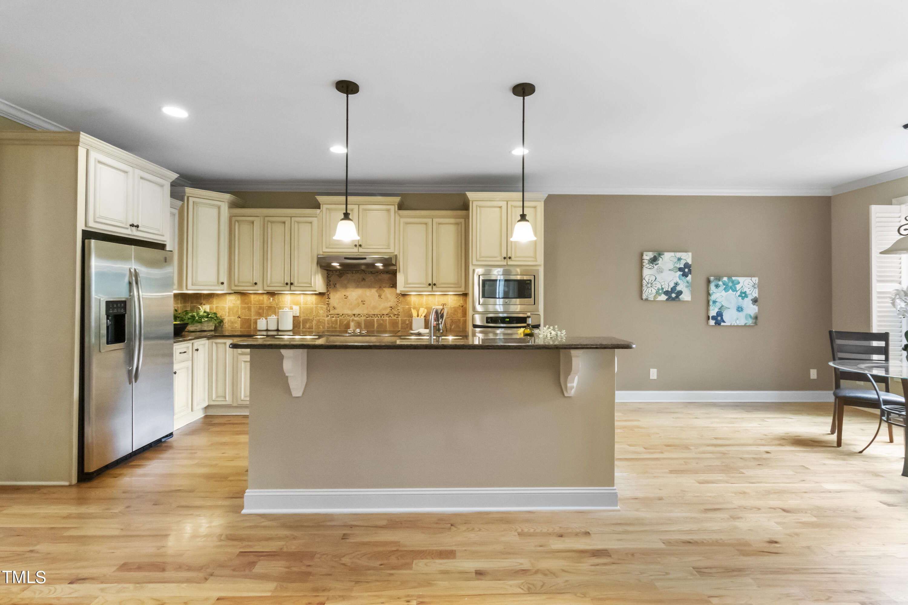 6507 Glendower Road Raleigh, NC 27613 - Photo 5 of 42 a kitchen with stainless steel appliances granite countertop a refrigerator a sink dishwasher a stove and a dining table with wooden floor